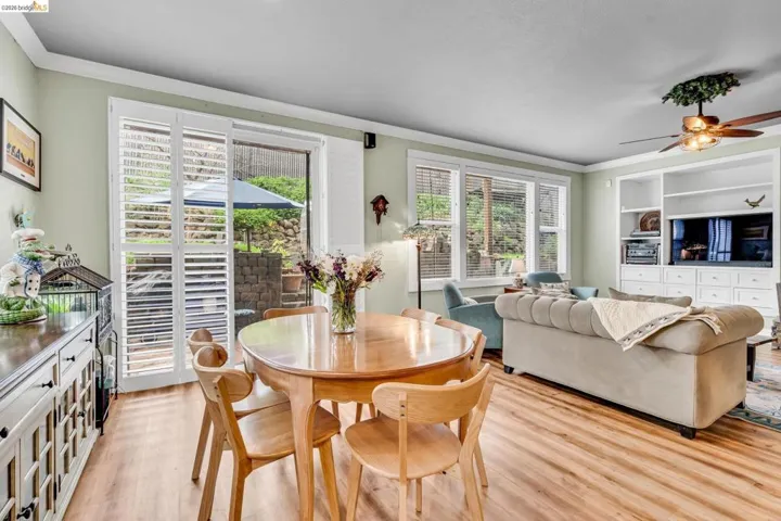 Dining room featuring a ceiling fan, light wood-style floors, and ornamental molding