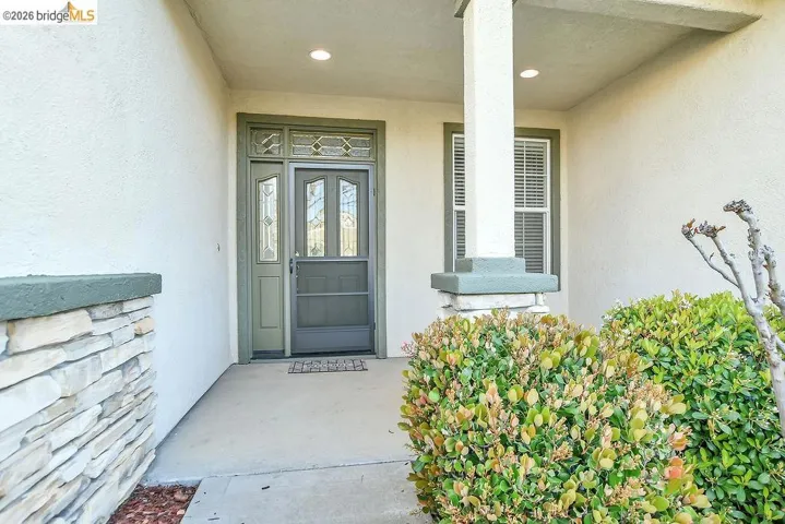 Entrance to property featuring stucco siding and a porch