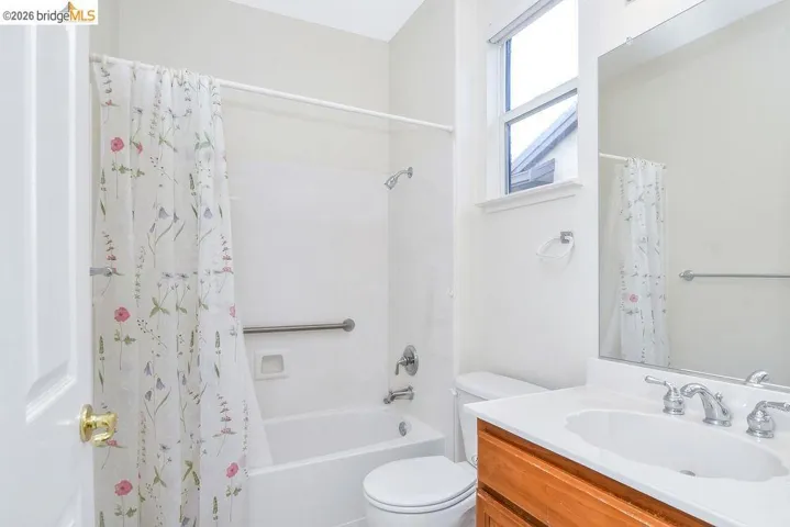 Bathroom with vanity and shower / bath combo with shower curtain