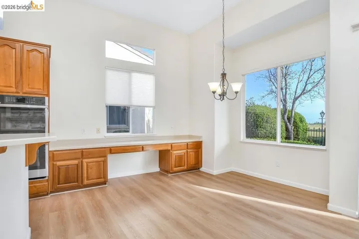 Unfurnished dining area with built in study area, light wood finished floors, and healthy amount of natural light