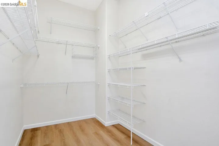 Walk in closet with light wood-style flooring