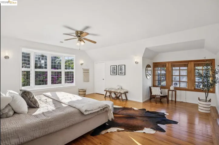 Bedroom featuring lofted ceiling, wood finished floors, and a ceiling fan