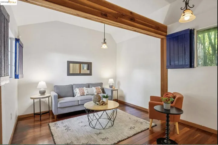Living room featuring vaulted ceiling and wood finished floors