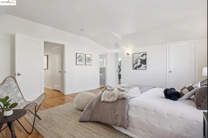 Bedroom with lofted ceiling and light wood-type flooring