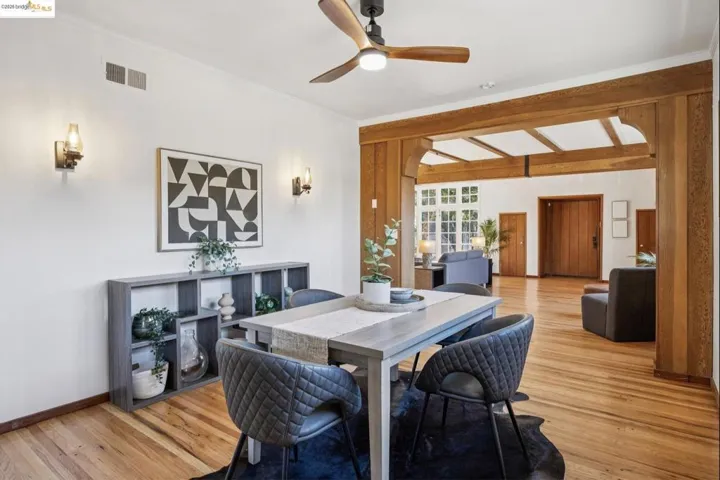 Dining area with light wood-style flooring, crown molding, and ceiling fan