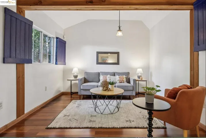 Living area with lofted ceiling with beams and dark wood finished floors