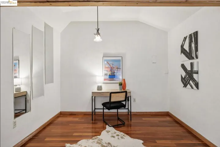 Office area featuring dark wood-style flooring and baseboards