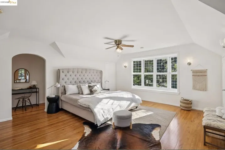 Bedroom featuring vaulted ceiling, light wood-style floors, and ceiling fan