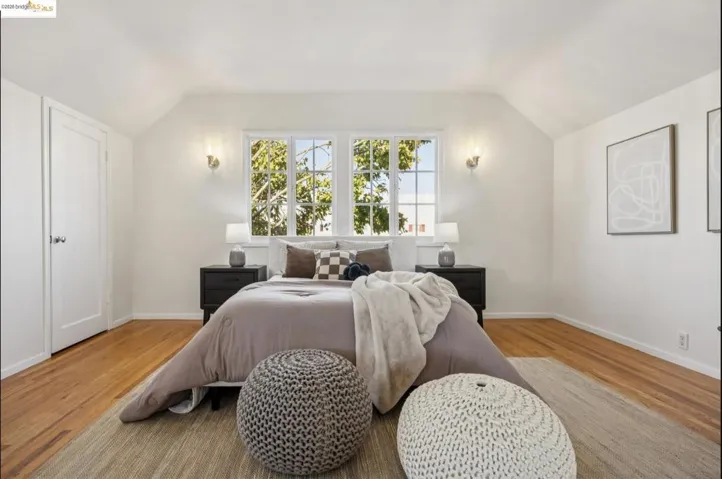 Bedroom with vaulted ceiling and light wood finished floors