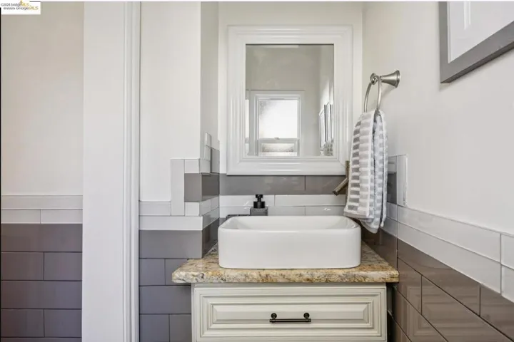 Bathroom with vanity, tile walls, and wainscoting