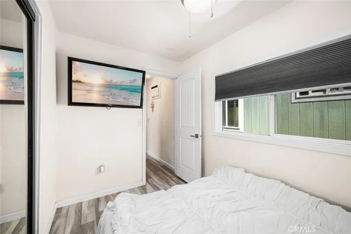 Main bedroom includes, ceiling fan, mounted TV, dual paned window