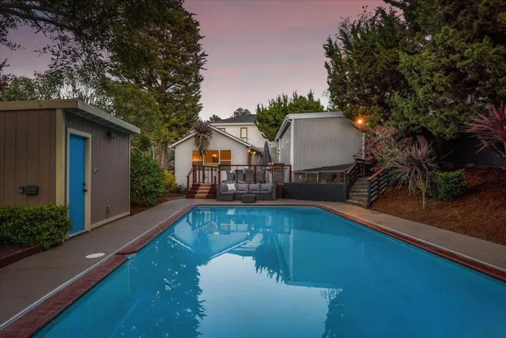 Viewing rear of home, guest house, pool, pool house, patio, deck and bunny shelter