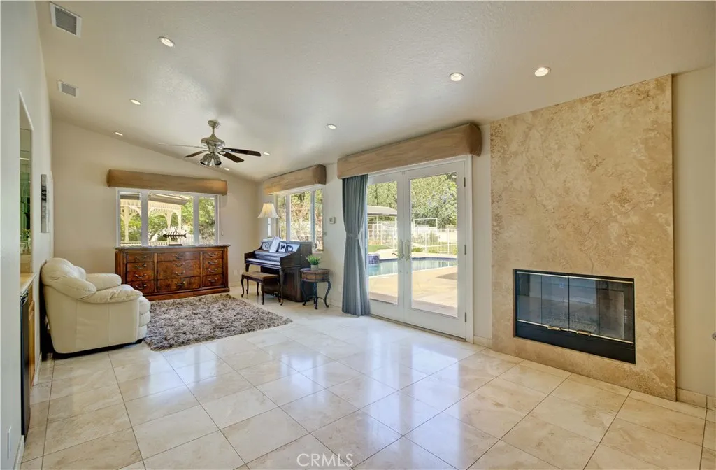 Primary bedroom sitting area with fireplace and french doors to the patio/pool