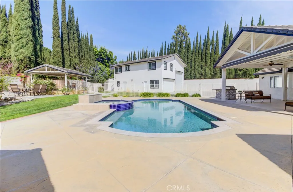 Gorgeous backyard showing pool and car barn and horse stalls