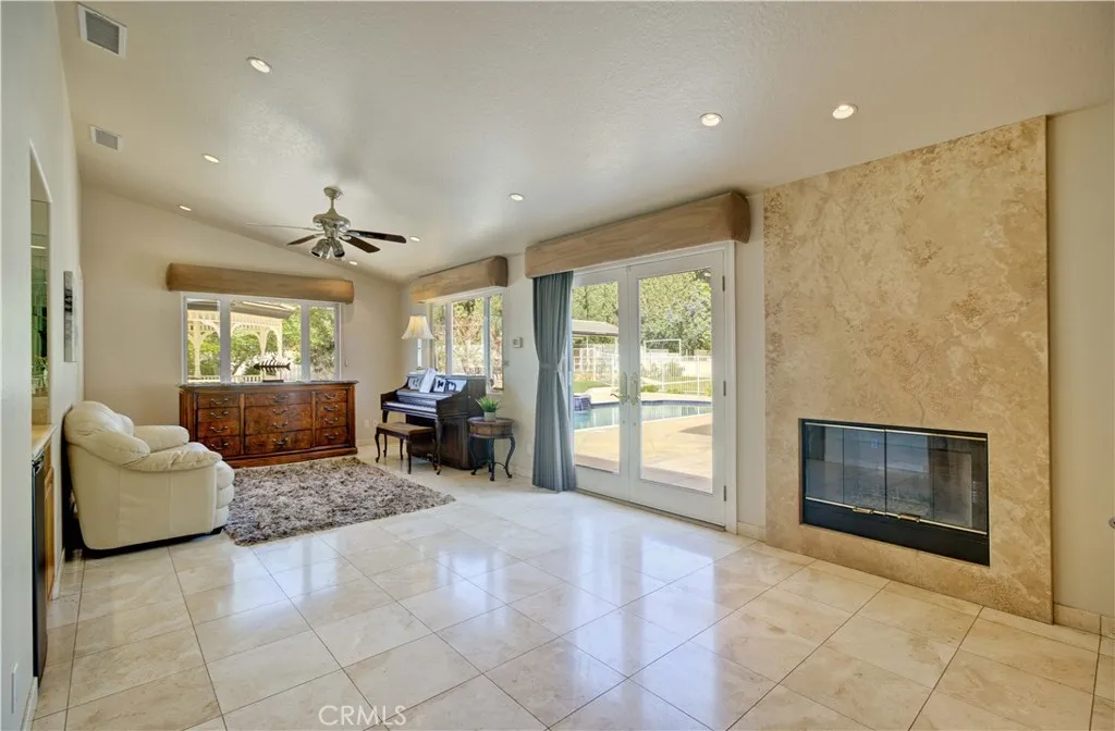 Primary bedroom sitting area with fireplace and french doors to the patio/pool