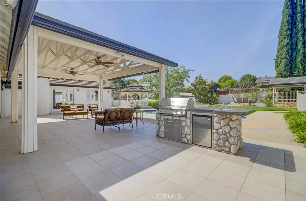 Built in BBQ and patio cover looking towards pool, gazebo and horse stalls