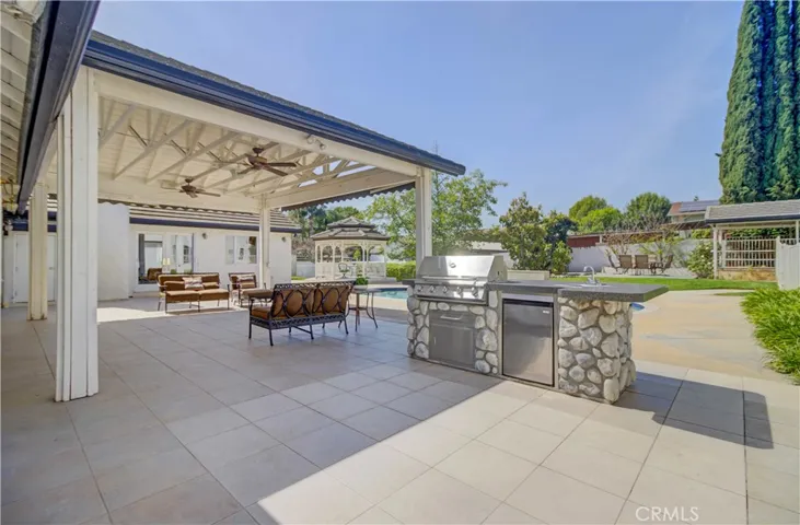Built in BBQ and patio cover looking towards pool, gazebo and horse stalls