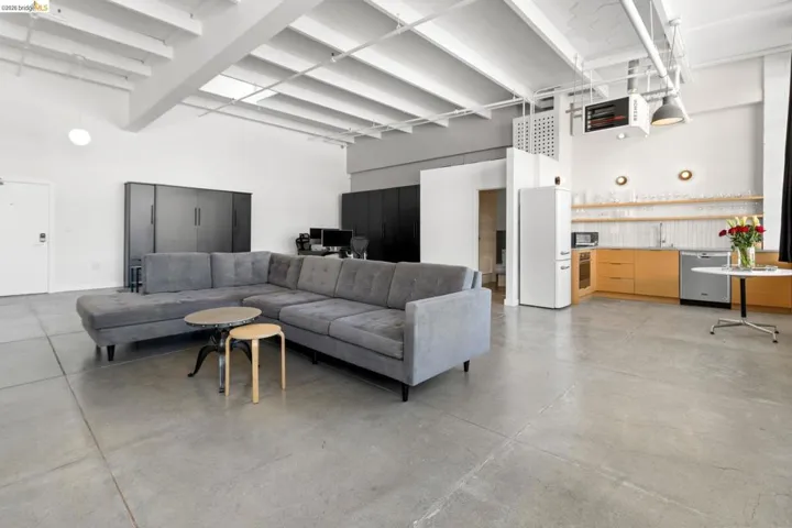 Living area with a high ceiling, finished concrete flooring, and a heating unit