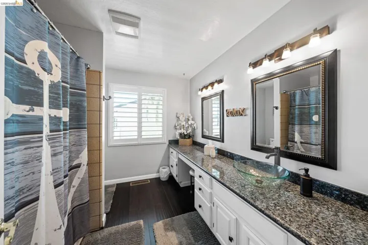Bathroom with vanity, dark wood finished floors, and a shower with curtain