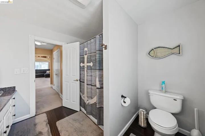 Full bath featuring vanity, dark wood-type flooring, and a shower with shower curtain