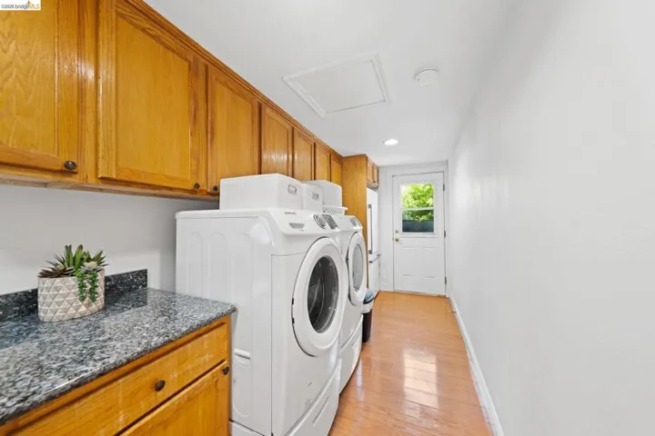 Laundry room with washer and clothes dryer, light wood-style floors, cabinet space, and recessed lighting