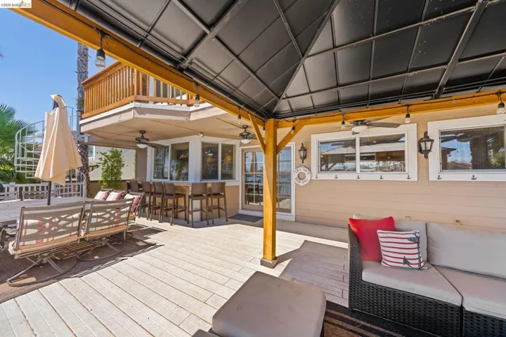 Wooden terrace with a ceiling fan and outdoor dining area