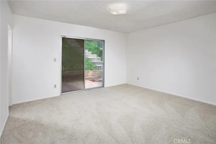 The spacious primary suite offers sliding glass doors to the backyard, new carpeting, ample closet space.