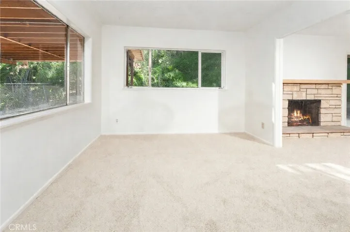 Adjacent to the kitchen is a formal dining room or family room with drop down lighting, multiple windows, closet storage, and new carpet. This flexible space could serve as a possible fourth bedroom by enclosing the cased opening to the living room.