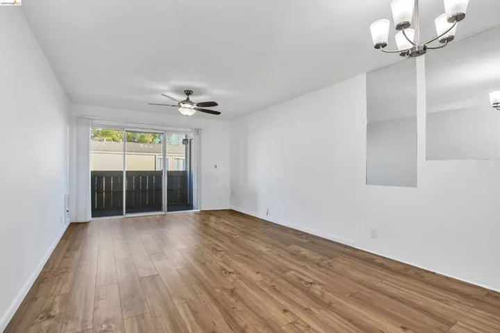 Unfurnished room featuring wood finished floors, ceiling fan, and hanging lights