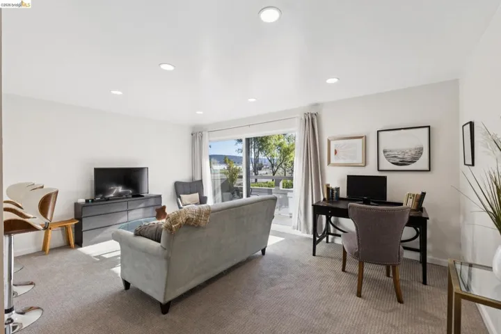 Carpeted living area featuring recessed lighting and a desk