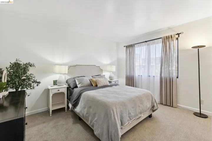 Bedroom featuring light colored carpet and baseboards