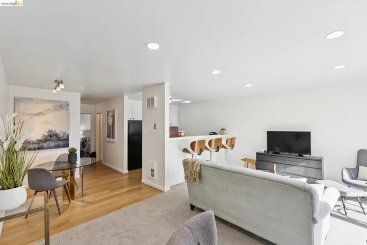 Living area with recessed lighting, light wood-type flooring, and light colored carpet