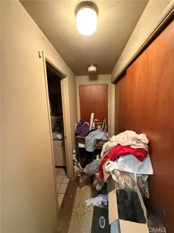 Hallway leads to main bathroom and additional bedroom with sliding glass door