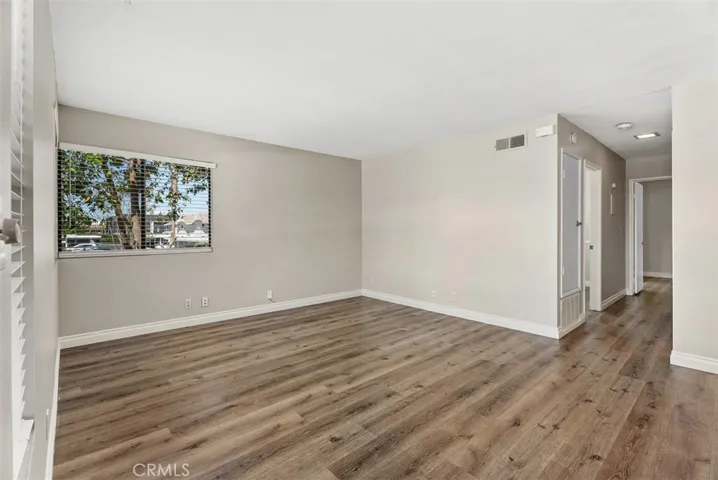 Living Room – Bright and spacious living area with wide-plank flooring, neutral tones, and large windows that bring in natural light. An open layout offers flexibility for everyday living and entertaining.
