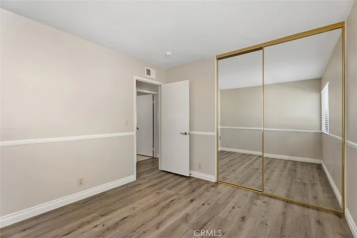 Bedroom – Secondary bedroom features mirrored closet doors, updated flooring, and a bright, neutral palette. Functional storage and a clean layout make the room feel open and inviting.
