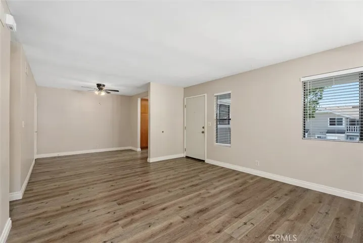 Living Area – Expansive main living space with multiple windows, wide-plank flooring, and a versatile layout. Ideal for creating distinct lounge and dining zones.

