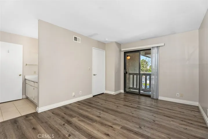 Primary Bedroom – Spacious primary bedroom with direct access to the balcony and an open layout that allows for flexible furniture placement. Soft neutral tones and updated flooring add to the move-in-ready feel.
