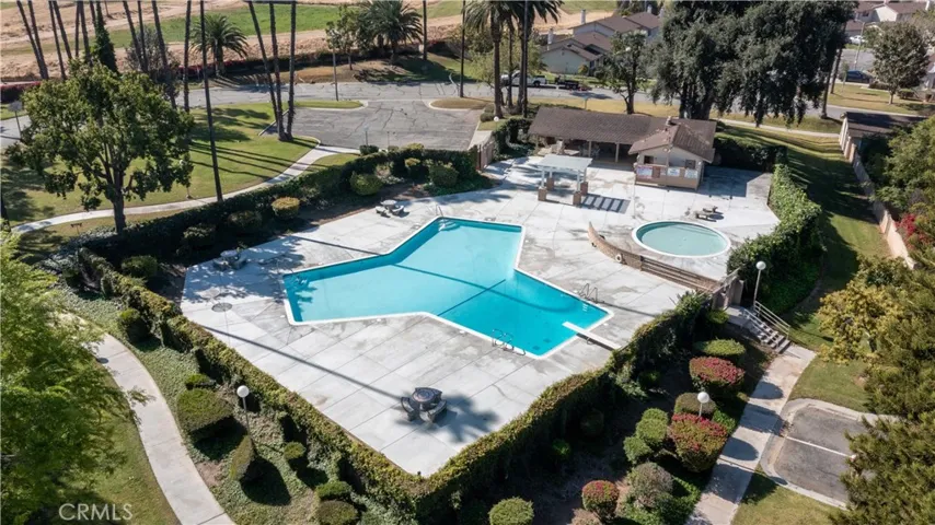 Aerial view of community pool and cabana, greenbelt space, walking path