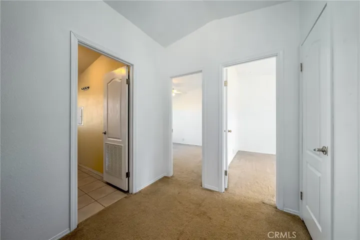 Hallway view into guest bathroom and 2 bedrooms