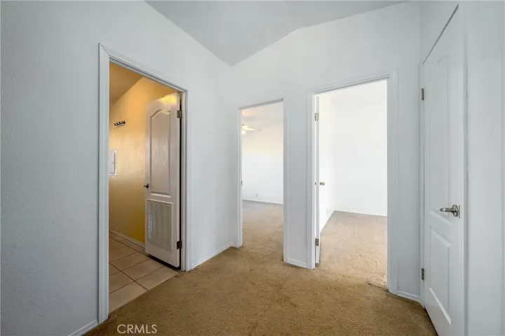 Hallway view into guest bathroom and 2 bedrooms