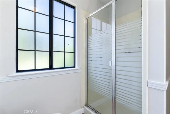 The primary bathroom has a separate shower area with a large linen cabinet.