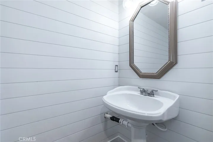The half bathroom has shiplap walls and a stylish barn door.