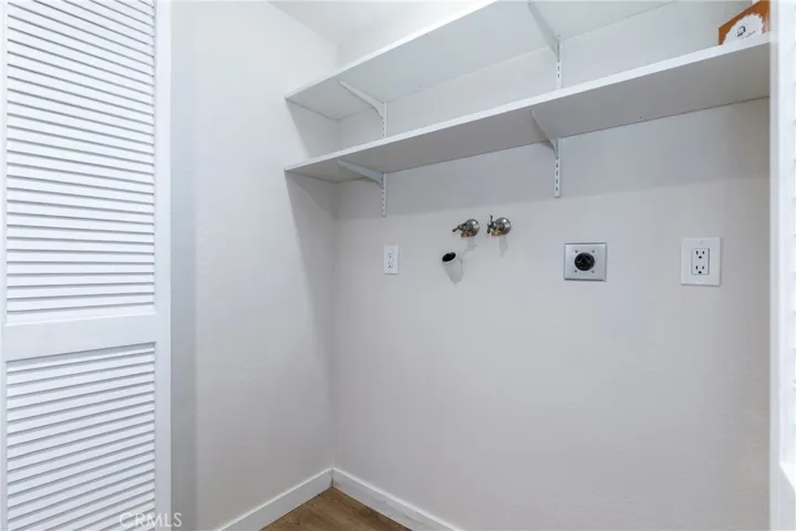 Behind bi-fold doors we find the laundry area with shelves and 220V.