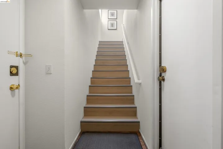 Stairs with a textured wall and baseboards