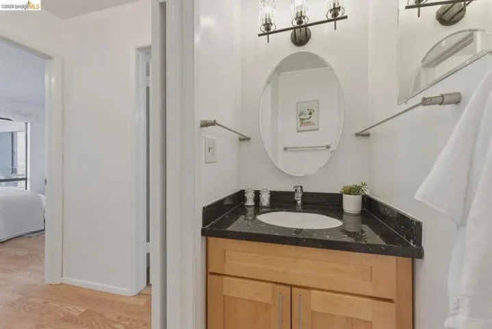 Ensuite bathroom featuring vanity and light wood-style flooring