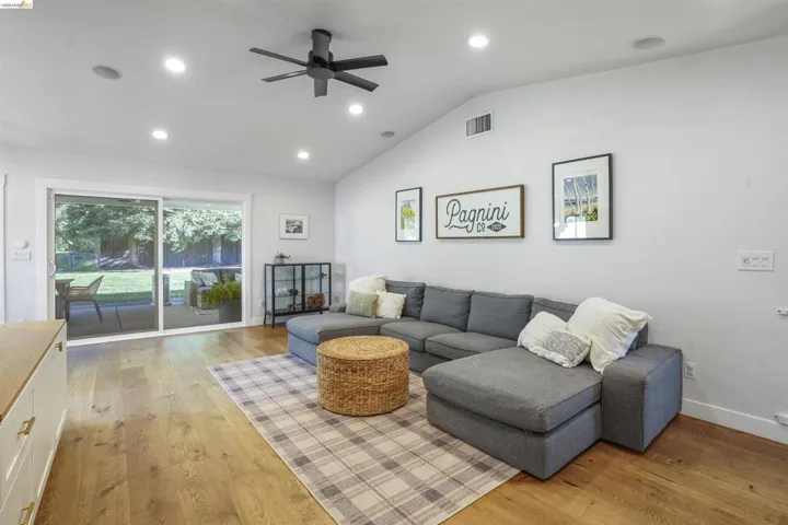 Living room featuring recessed lighting, a ceiling fan, lofted ceiling, and light wood finished floors