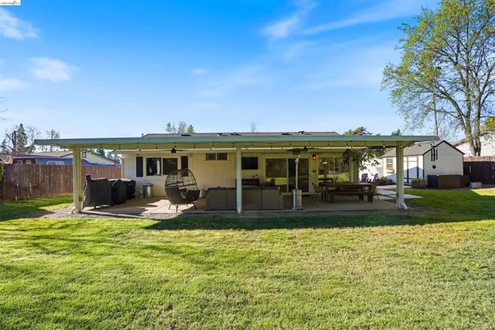 Rear view of property featuring a patio, an outdoor hangout area, and a ceiling fan