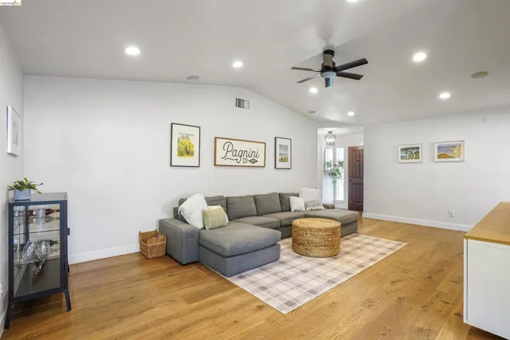Living area with light wood-style flooring, recessed lighting, and a ceiling fan