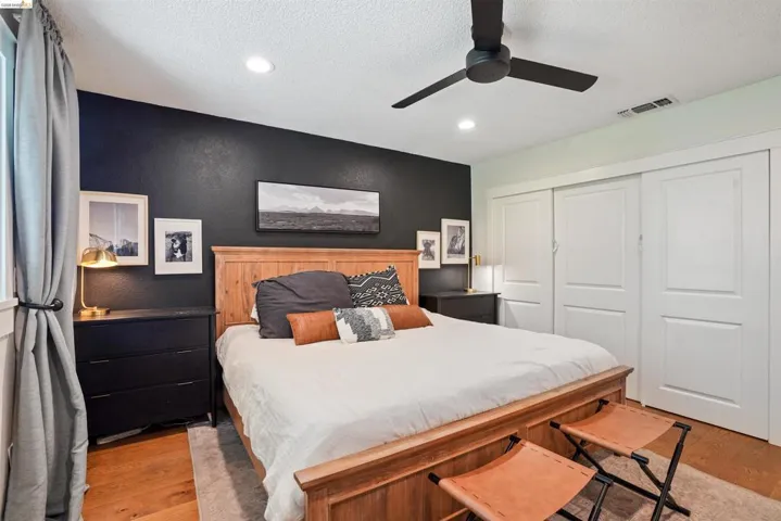 Bedroom featuring a closet, light wood finished floors, a ceiling fan, a textured ceiling, and recessed lighting