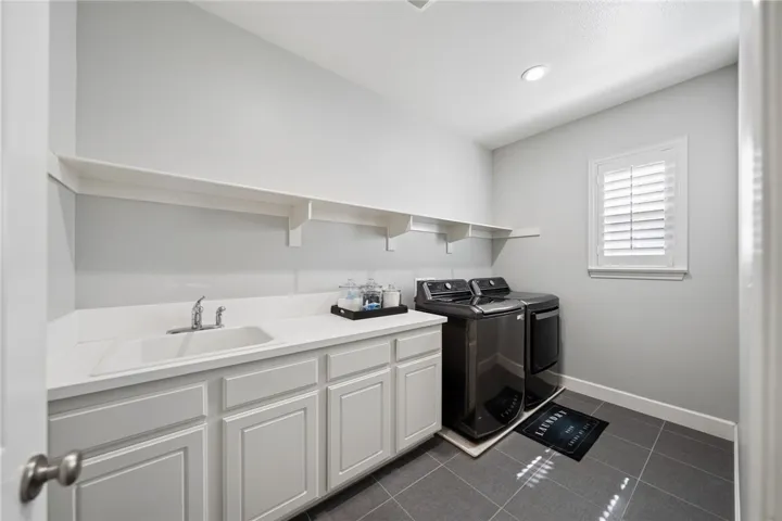 Upstairs laundry room with sink and storage